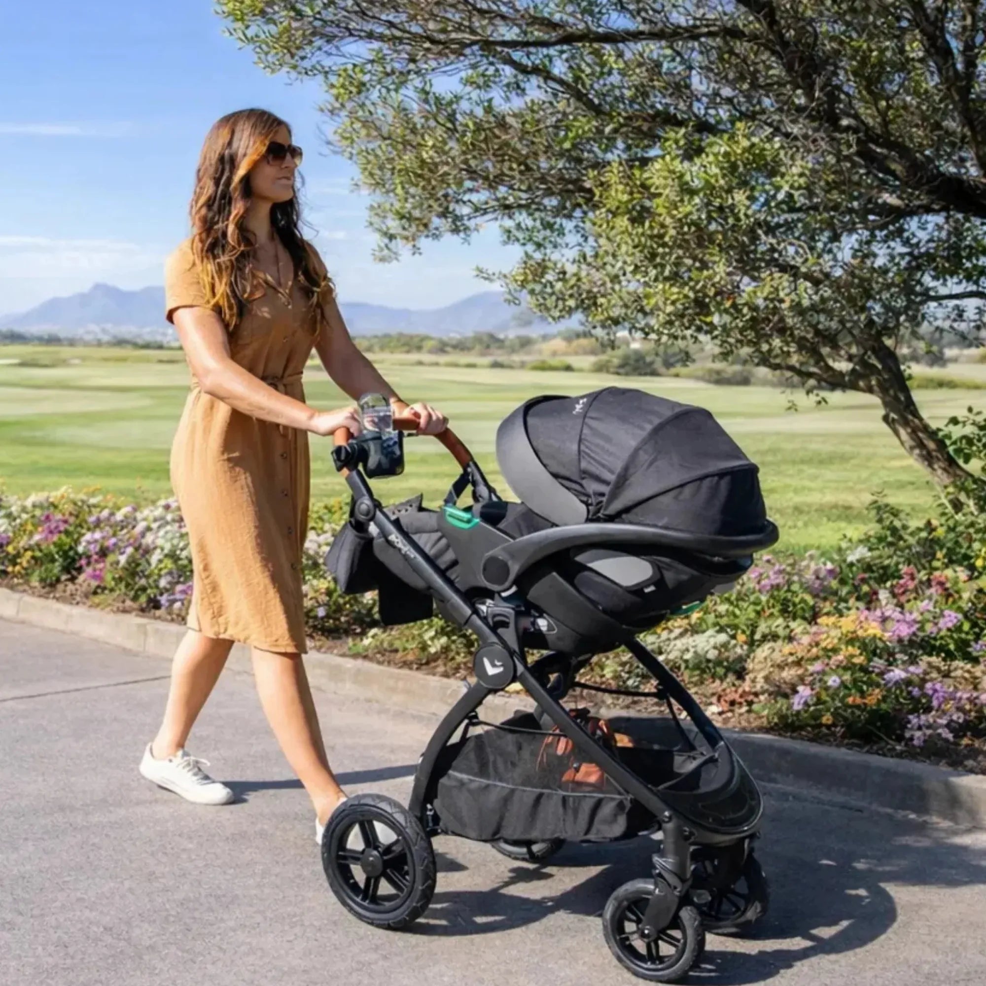 Mimi LUNO 3-in-1 Travel System shown outdoors with AVARO infant car seat attached